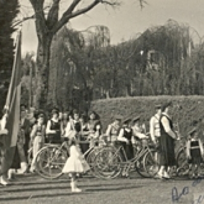 Aluena Cavagnoli Meneguini, juntamente com estudantes da Escola São José, em 1958, durante hasteamento das bandeiras na Praça da Bandeira, em Flores da Cunha. Na foto, Aluena é a menina vestida de branco, pouco mais à frente. Ela era baliza. (Foto/arquivo Zuleima Cavagnoli)