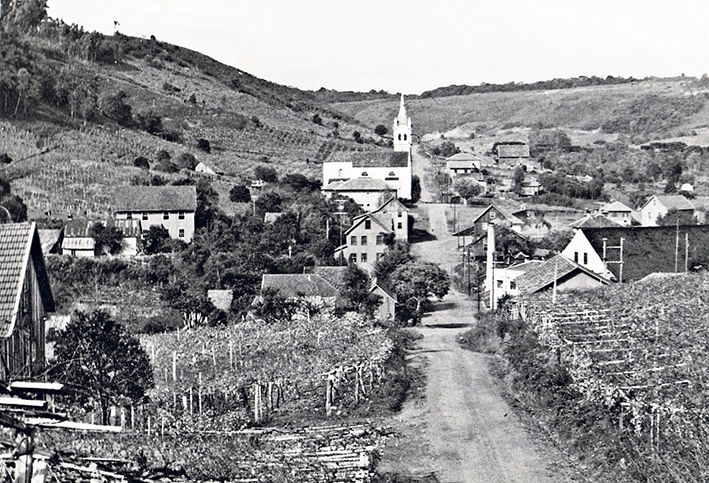 Centro da vila, anos de 1960, ainda com a Igreja Matriz velha (1905), podendo-se observar os diversos casarões de madeira.  - Museu dos Freis Capuchinhos/ Divulgação