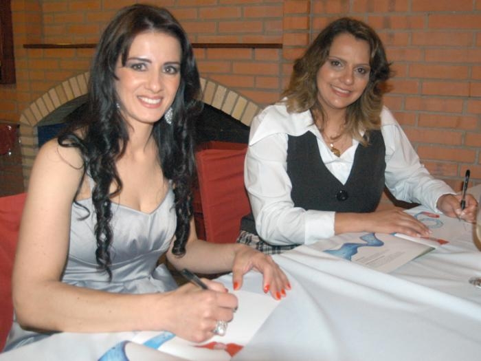 As autoras Andréia Costa Tonello e Juliana Rohde autografam a obra. - Danubia Otobelli