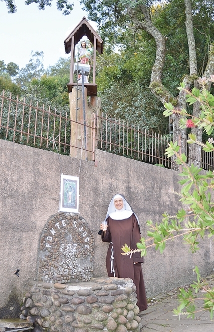 Irmã Clara convida a comunidade a participar da celebração em frente à bica d’água. - Larissa Verdi
